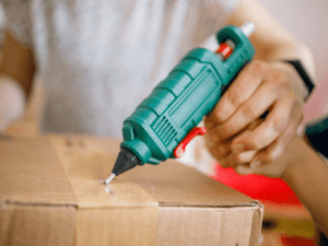 Utilisation pistolet à colle sur carton d'emballage